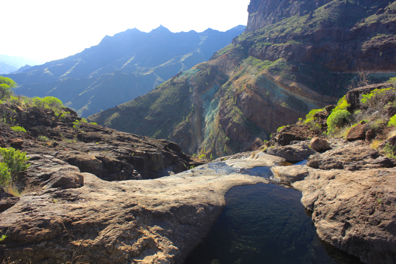 Wasserloch beim Abstieg der Azulejos Wanderung. Im Hintergrund, Mitte rechts, die bunten Felsen von Los Azulejos