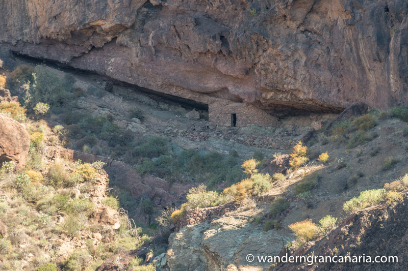 Höhlenhaus aus Naturstein unter einer Felswand, Gran Canaria Westen