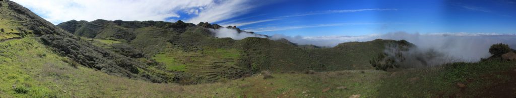 Grüne Wiesen und Terrassenfelder mit Passatwolken auf der Nordostseite der Insel Gran Canaria